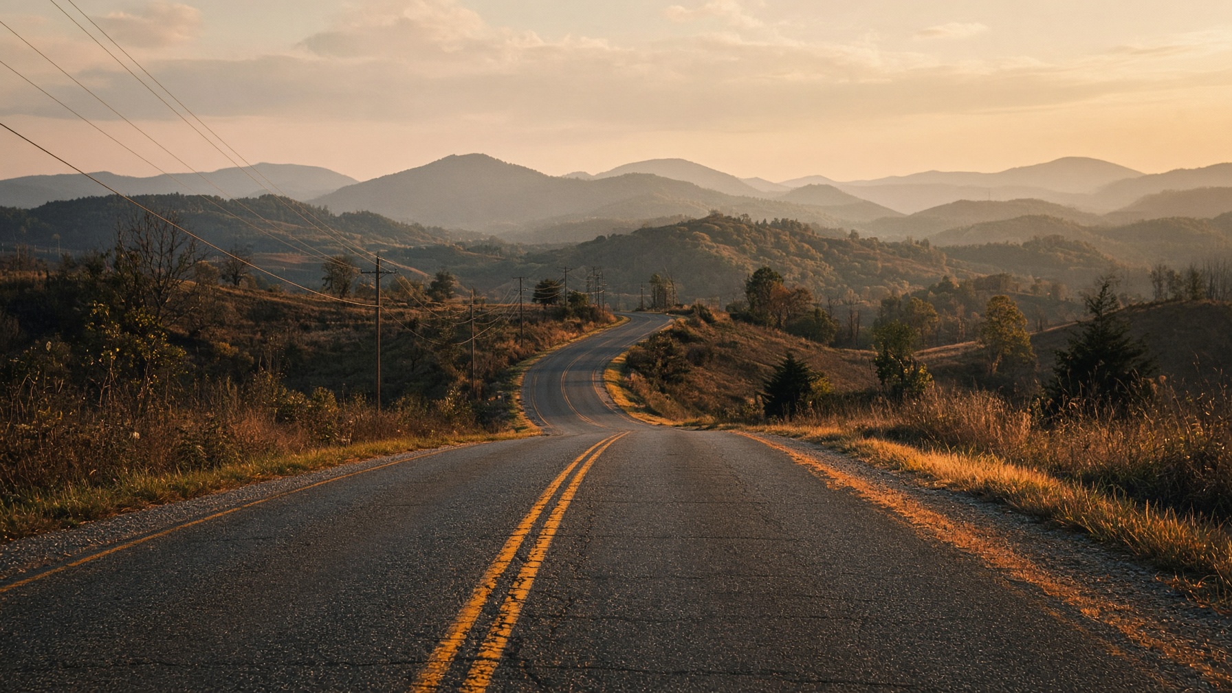 Empty two-lane rural highway in the Appalachian foothills at golden hour